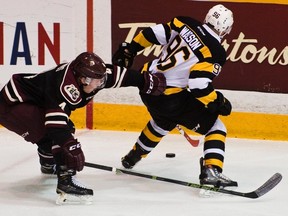 Peterborough Petes’ Matthew Timms grabs Kingston Frontenacs’ Spencer Watson during first-period OHL action at the Peterborough Memorial Centre on Sunday night. (Jessica Nyznik/Postmedia Network)