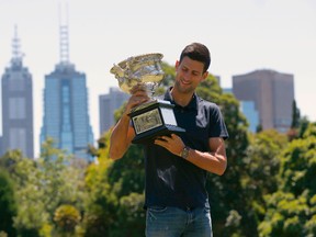 Serbia's Novak Djokovic looks at the men's singles trophy during a photocall, a day after winning his final match at the Australian Open tennis tournament at Government Hill in Melbourne, Australia, February 1, 2016. REUTERS/Jason Reed