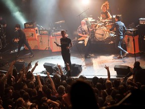 A picture taken on November 13, 2015 shows American rock group Eagles of Death Metal performing on stage at the Bataclan concert hall in Paris, a few moments before men armed with assault rifles and shouting "Allahu akbar" ("God is great!") stormed into the venue. Eagles of Death Metal, the US band whose audience was massacred in the Paris attacks, on November 18, 2015 called for "love and compassion" and put its shows on hold. The California rock band, in its first full statement since Friday's bloodbath, said it was "horrified" and "still trying to come to terms with what happened." AFP PHOTO / ROCK&FOLK / MARION RUSZNIEWSKI