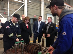 Energy Minister Margaret McCuaige-Boyd, second from left, and Minister for Economic Development and Trade Deron Bilous, middle, watch millwright students at NAIT working on a compressor. Jodie Sinnema/Postmedia Network