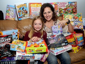 Sophia Christopher, 10, a Grade 5 student at Winston Churchill Public School, collected about 30 board games and gave them to Heather Haynes on Thursday. Haynes will deliver them to children in Tanzania and Congo. (Ian MacAlpine/The Whig-Standard)