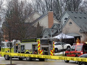 Police and fire officials investigate a house fire that killed five people at a home in Novi, Mich., Sunday, Jan. 31, 2016. Authorities say five restaurant workers were killed in the house fire near Detroit. The cause of the blaze is under investigation.  (Brandy Baker/Detroit News via AP)