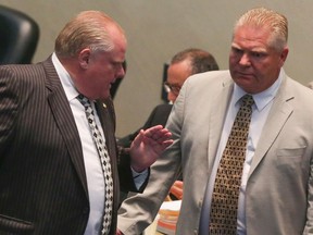 Then-mayor Rob Ford with then-councillor Doug Ford at city council on August 25, 2014. (Dave Thomas/Toronto Sun)