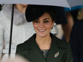 Kate the Duchess of Cambridge shelters under an umbrella as she leaves with royal family members after attending the traditional Christmas Day church service at St. Mary Magdalene Church in Sandringham, England, Friday, Dec. 25, 2015.  (AP Photo/Matt Dunham)
