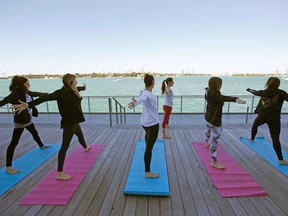 In this Jan. 24, 2016, photo, Paula Walker, background center, an instructor with Green Monkey Yoga, leads a yoga class at the Mondrian South Beach Hotel in Miami Beach, Fla. (AP Photo/Wilfredo Lee)