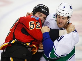 Vancouver Canucks forward Brandon Prust fights with Calgary Flames forward Brandon Bollig during first period NHL hockey action in Calgary on Oct. 7, 2015. (THE CANADIAN PRESS/Jeff McIntosh)