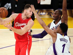 Los Angeles Clippers forward Blake Griffin, left, passes over Los Angeles Lakers forward Kobe Bryant, middle, as guard D’Angelo Russell looks on during NBA play in Los Angeles, Friday, Dec. 25, 2015. (AP Photo/Chris Carlson)