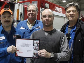Lanxess workers, from left, Wayne Mathers, Ron Small, Chris Duval, and Lloyd Churchill were honoured by the Canadian Red Cross Tuesday for helping save a contractor's life in October. They're pictured holding a company plaque, also awarded Tuesday, for Lanxess' commitment to CPR training with the Red Cross. (Tyler Kula/Sarnia Observer/Postmedia Network)