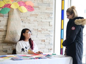 Agnes Lei, left, chats with Ali Parke at an Eating Disorder Awareness Week information table at Brescia College in London Tuesday.  (DEREK RUTTAN, The London Free Press)