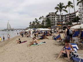 Tourists are seen along the beach resort of Puerto Vallarta, Mexico, December 31, 2015. REUTERS/Henry Romero
