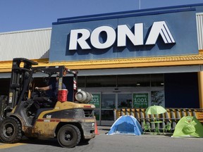 A man drives a forklift in front of a Rona home improvement store in St. Eustache, Que., just outside Montreal, on July 16, 2015. The Lowe's home improvement chain is buying Quebec-based Rona Inc. in a deal valued at $3.2 billion. (THE CANADIAN PRESS/Ryan Remiorz)