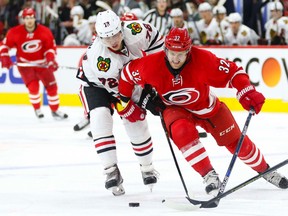 Carolina Hurricanes forward Kris Versteeg tries to control the puck against Chicago Blackhawks forward Artemi Panarin during the second period at PNC Arena in Raleigh on Jan. 26, 2016. (James Guillory/USA TODAY Sports)