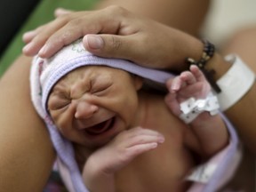 Sueli Maria (obscured) holds her daughter Milena, who has microcephaly, (born seven days ago), at a hospital in Recife, Brazil, January 28, 2016. Milena was born with microcephaly, a neurological disorder that damaged her brain and also affected her vision, a condition associated with an outbreak of Zika virus in Brazil. (REUTERS/Ueslei Marcelino)