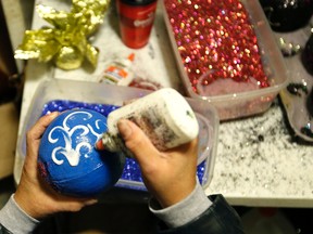Chanel Lafargue decorates coconuts, gorgeous pieces often referred to as "Golden Nuggets," inside her studio in New Orleans, Tuesday, Jan. 5, 2016. (AP Photo/Gerald Herbert)