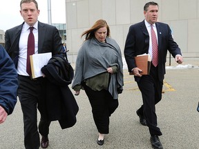 Melodie Gliniewicz, the wife of a disgraced Illinois police officer who staged his suicide, walks out the Lake County Courthouse with her lawyers after pleading not guilty to charges that she assisted her husband in siphoning money from a youth program, in Waukegan, Ill., Wednesday, Feb. 3, 2016, in Waukegan, Ill. (Mark Welsh /Daily Herald via AP)
