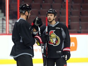 Marc Methot (left) and Erik Karlsson of the Senators chat during practice on Feb. 3. (Jean Levac, Postmedia Network)