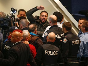 A large group of Toronto cabbies are removed from City Hall by security and police after a fracas during the council meeting Wednesday, February 3, 2016. (Jack Boland/Toronto Sun)