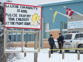 Members of the RCMP stand outside the La Loche Community School in La Loche, Sask. Monday, Jan. 25, 2016. A mass shooting took place at the northern Saskatchewan school. THE CANADIAN PRESS/Jonathan Hayward