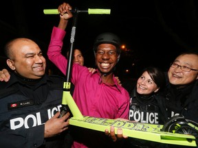 Toronto Police officers from 32 Division saw Devon Phillips navigating the streets earlier this week with the aid of a battered shopping cart. The whole division decided to chip in and get Phillips a scooter and helmet to give him greater mobility.Left to right are Const. Nir Lohdi, Phillips, Const. Neil Webb, Const. Kate Cowie and Sang Park on Feb. 3, 2016. (Stan Behal/Toronto Sun)