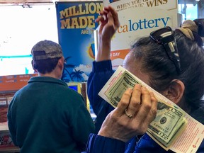 In this Jan. 13, 2016 file photo, customers wait to buy lottery tickets at the Blue Bird liquor store in Hawthorne, Calif. Nobody showed up at a state lottery office by 5 p.m. Thursday with the winning $63 million California Lottery ticket or submitted a verified claim for the prize, lottery spokesman Alex Traverso said. (AP Photo/Damian Dovarganes, File)