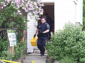 In this file photo a Greater Sudbury Police forensics officer leaves a home on Bessie Street in the Donovan, where the alleged suspect in a murder on Tuesday afternoon lived.Gino Donato/The Sudbury Star