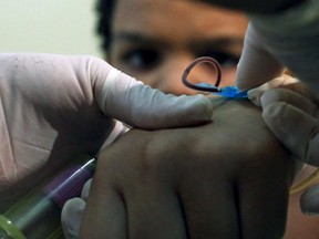 A health agent collects blood from a child with a new test kit that rapidly diagnoses three different mosquito-borne viruses in Sao Paulo, Brazil, January 18, 2016. (REUTERS/Rodrigo Paiva)