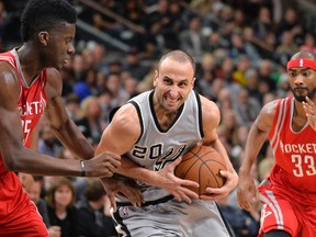 San Antonio Spurs guard Manu Ginobili (20), of Argentina, drives around Houston Rockets center Clint Capela, left, of Switzerland, as Houston's Corey Brewer looks on during the second half of an NBA basketball game, Saturday, Jan. 2, 2016, in San Antonio. San Antonio won 121-103. (AP Photo/Darren Abate)