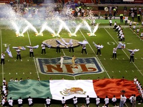 In this Oct. 2, 2005 file photo, performers unfurl a Mexican flag prior to the start of the game between the Arizona Cardinals and San Francisco 49ers at Azteca Stadium in Mexico City. (AP Photo/Marco Ugarte)