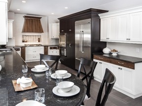 This kitchen features three cabinetry colours, a marble-look quartz countertop, large scale porcelain tile flooring, a 1.3-metre wide kitchen sink and a large, professional style refrigerator. (Designer: Cassandra Nordell/Copyright William Standen Co. 2015)