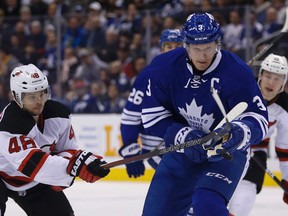 New Jersey Devils forward Tyler Kennedy (48) tries to swat the puck away from Toronto Maple Leafs defenceman Dion Phaneuf in Toronto on Thursday February 4, 2016. (Jack Boland/Toronto Sun/Postmedia Network)