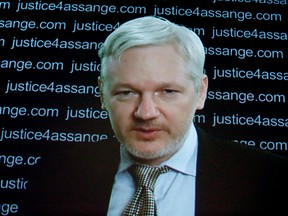 WikiLeaks founder Julian Assange is seen on a screen as he addresses the media from the London embassy of Ecuador, on  Feb. 5, 2016, where he has been holed up for some 3½ years to avoid extradition to Sweden for questioning about alleged sexual offenses.  A UN human rights panel says Assange has been "arbitrarily detained" by Britain and Sweden since December 2010. The UN Working Group on Arbitrary Detention said his detention should end and he should be entitled to compensation. (AP Photo/Frank Augstein)