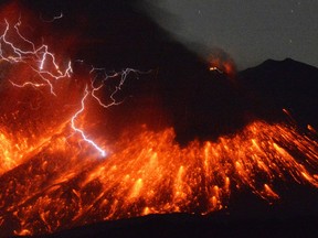 In this photo taken with a 15-second exposure by a fixed-position camera in Ushinefumoto in Tarumizu, Kagoshima Prefecture, lightning flashes above flowing lava as Sakurajima, a well-known volcano, erupts Friday evening, Feb. 5, 2016 in southern Japan. Japan's Meteorological Agency said Sakurajima on the island of Kyushu erupted at around 7 p.m. (1000 GMT). The distance between Sakurajima and Ushinefumoto is about 9 kilometers (5.6 miles). (Kyodo News via AP)
