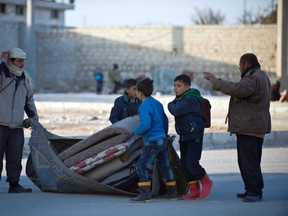 Syrians prepare to walk toward Turkey at the Bab al-Salam border gate, Syria, Friday, Feb. 5, 2016. Turkish officials say thousands of Syrians have massed on the Syrian side of the border seeking refuge in Turkey. Officials at the government’s crisis management agency said Friday it was not clear when Turkey would open the border to allow the group in and start processing them. The refugees who fled bombing in Aleppo, were waiting at the Bab al-Salam crossing, opposite the Turkish province of Kilis. (Depo Photos via AP) TURKEY OUT