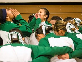 In this Feb. 2, 2016 photo provided by Richard Johnson, the girls basketball team at Flagstaff, Ariz., High School does a cheer with their hair tied back in traditional Navajo buns before taking the floor for pre-game warmups. (Richard Johnson via AP)