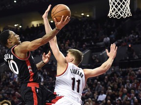 Raptors’ DeMar DeRozan (right) drives to the basket on Trail Blazers forward Meyers Leonard on Thursday. (AP)