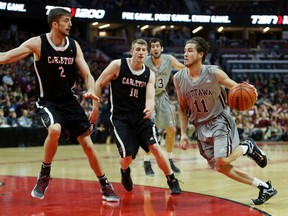 Ottawa Gee-Gees' Mike L'Africain drives on Carleton Ravens' Cameron Smythe, left, and Connor Wood on Feb. 5. (Darren Brown, Postmedia Network)