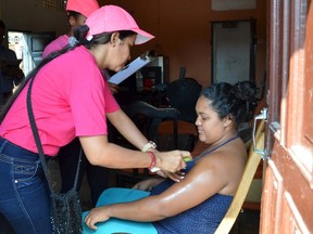 A health worker sprays mosquito repellent on a pregnant woman's arm, during a campaign to fight the spread of Zika virus in Soledad municipality near Barranquilla, Colombia, in this February 1, 2016 handout photo supplied by the Soledad Municipality. REUTERS/Aleydis Coll/Soledad Municipality/Handout via Reuters