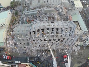 In this photo taken from a drone mounted camera, rescue workers search a collapsed building from an early morning earthquake in Tainan, Taiwan, Saturday, Feb. 6, 2016. A powerful, shallow earthquake struck southern Taiwan before dawn Saturday. (AP Photo)