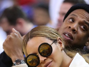 Jay-Z  and Beyonce (C) watch the game between the Golden State Warriors and the Oklahoma City Thunder during the third quarter at Oracle Arena. The Warriors won 116-108. Mandatory Credit: Cary Edmondson-USA TODAY Sports