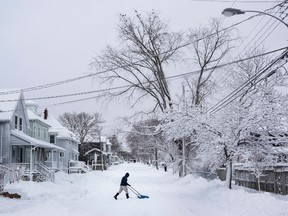 A man clears snow from the middle of the street during a snow storm in Halifax, NS on Wednesday, January 13, 2016. A winter storm warning remains in effect for much of the Maritimes bringing a predicted 15 to 25 centimetres of snow. THE CANADIAN PRESS/Darren Calabrese