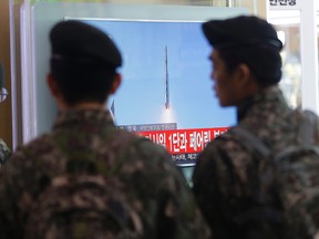 South Korean army soldiers watch a TV news program with a file footage about North Korea's rocket launch at Seoul Railway Station in Seoul, South Korea, Sunday, Feb. 7, 2016. North Korea on Sunday defied international warnings and launched a long-range rocket that the United Nations and others call a cover for a banned test of technology for a missile that could strike the U.S. mainland. (AP Photo/Ahn Young-joon)