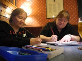 Lorrie Ridge, left, and Charlotte Sherwood try their hand at colouring at the Old English Pub in Gananoque. (Wayne Lowrie/Postmedia Network)