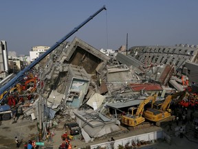 Rescue personnel work at the site where a 17-storey apartment building collapsed, after an earthquake in Tainan, southern Taiwan February 7, 2016. REUTERS/Tyrone Siu