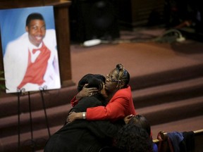 Janet Cooksey (L), is embraced as she attends the funeral for her son Quintonio LeGrier in Chicago, Illinois, January 9, 2016. The U.S. Department of Justice is investigating the city police department over its use of deadly force, especially against minorities. The shooting deaths of two black people - college student Quintonio LeGrier, 19, and Bettie Jones, 55, a grandmother of 10 - by a police officer late last month have increased tensions.  REUTERS/Joshua Lott
