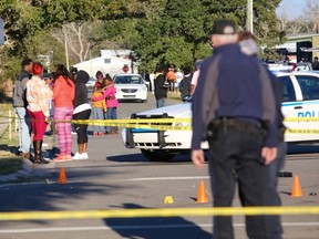 A woman embraces two children near the intersection of Davis Avenue and Ladnier Street in Pass Christian after a shooting on Sunday, Feb. 7, 2016. South Mississippi police say a shooting after a Mardi Gras parade in Pass Christian has left two people dead and four others wounded. (Amanda McCoy/The Sun Herald via AP) /The Sun Herald via AP)