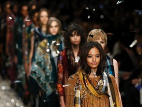 Models present creations from the Burberry Prorsum Autumn/Winter 2015 collection during London Fashion Week in this February 23, 2015 file photo. British luxury fashion brand Burberry said on February 5, 2016 it would merge its four annual catwalk shows into two and make its runway collections available to shoppers immediately. REUTERS/Suzanne Plunkett/Files