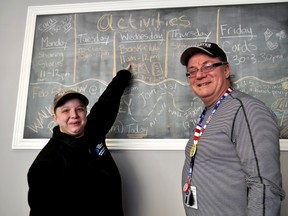 London InterCommunity Health Centre volunteer Jessica Ellis (left), and health outreach program facilitator Len Hughes stand next to a schedule of new programming available to clients at the centre on Dundas Street February 5, 2016. CHRIS MONTANINI\LONDONER\POSTMEDIA NETWORK