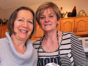 Joanna Kazanecki, right, and her friend Donna Longo hold a plate of finished paczki in Kazanecki's Sarnia home Monday, as more dough waits in front of them to be cooked into the traditional Polish treat. The pastry is traditionally made before the start of lent. (Tyler Kula/Sarnia Observer/Postmedia Network)