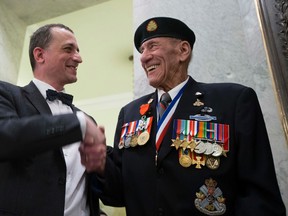 EDMONTON, AB.-- French Consul General in Vancouver Jean-Christophe Fleury raises the hand of Douglas Maurice White,US/Canadian First Special Service Force after receiving the Medal of the Legion of Honour, one of France’s highest distinctions, during an official ceremony at the Alberta Legislature on February 8,  2016 in Edmonton. To celebrate the 70th anniversary of D-Day landings, the French government has decided to bestow the Legion of Honour award to some of the living Canadian veterans who participated in D-Day and the Battle of Normandy operations.