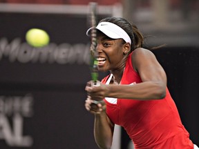 Canada's Francoise Abanda returns a shot to Belarus' Aliaksandra Sasnovich during the opening match of the Fed Cup tie, Saturday Feb. 6, 2016, in Quebec City. THE CANADIAN PRESS/Jacques Boissinot